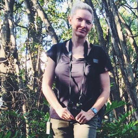 Woman hiking in a forest wearing outdoor gear